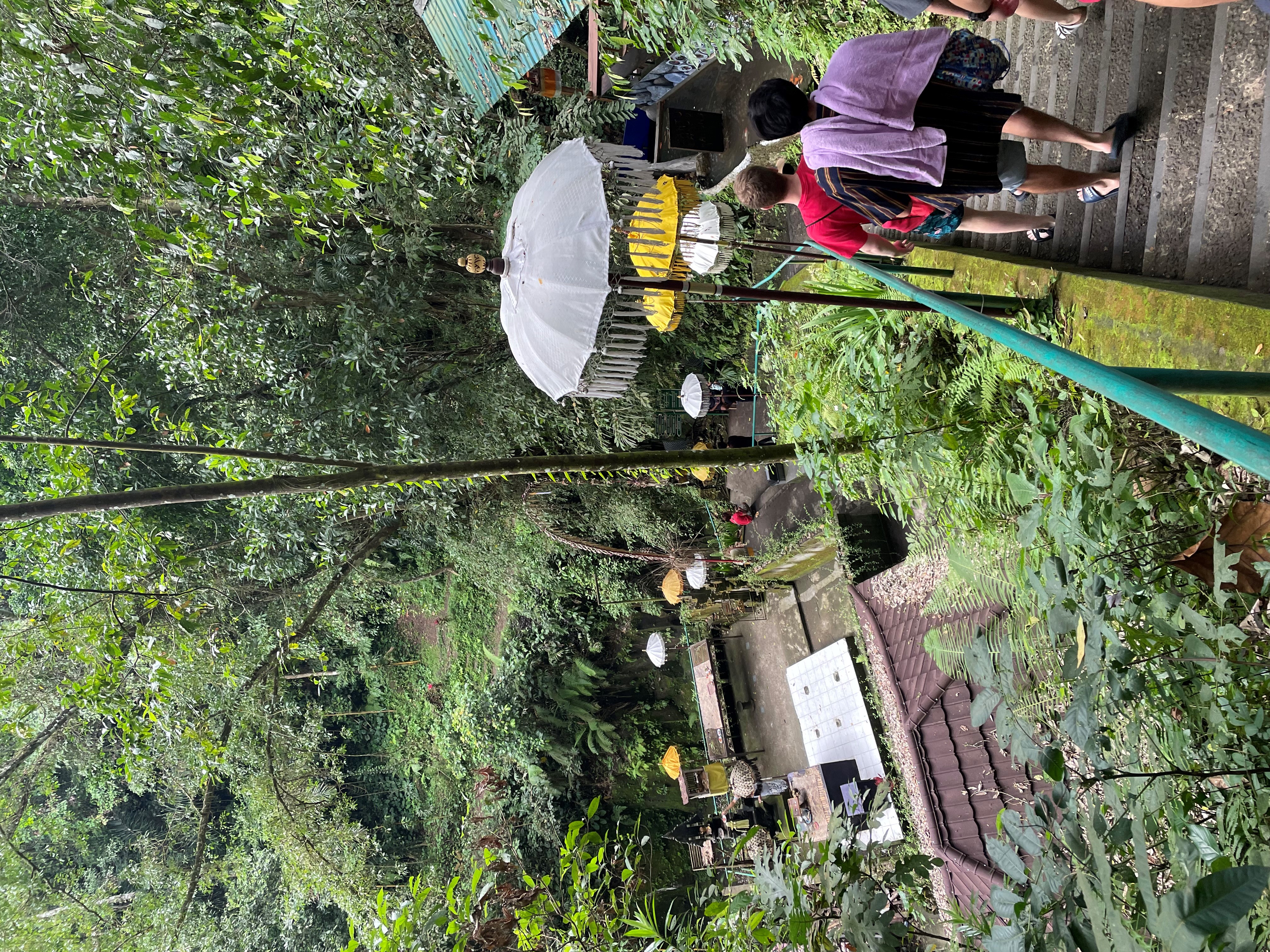 Students descend to a waterfall in Denpasar